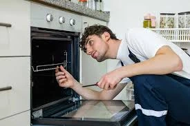 Technician inspecting the inside of a built-in oven
